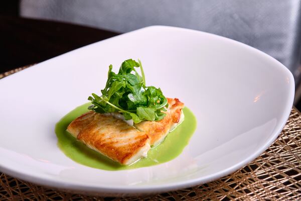 Livingston's halibut is served with green herb puree, watercress, baby arugula, Meyer lemon and grilled asparagus. Courtesy of Brandon Amato