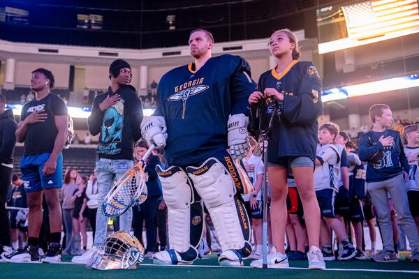 Georgia Swarm goalie Craig Wende and Karaline Apoian stand at attention during the National Anthem at a recent Swarm lacrosse game. Courtesy of Georgia Swarm