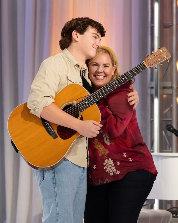 This image released by Disney shows contestant Slater Nalley, left, embracing his English teacher Mrs. Davis during auditions for the singing competition series "American Idol" in Nashville, Tenn. (Eric McCandless/Disney via AP)