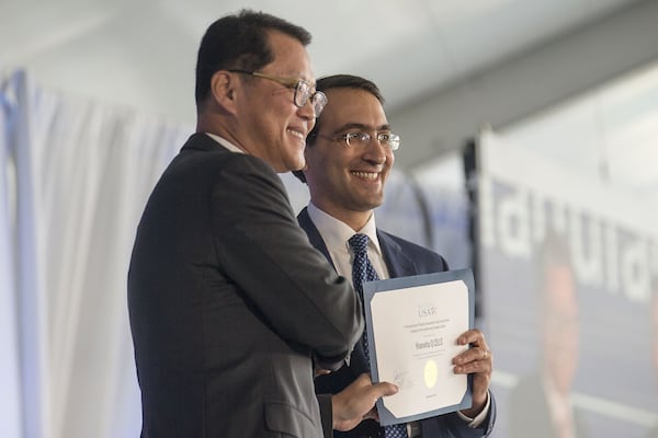 Dalton, Georgia — Hanwha Q Cells CEO Charles Kim (left) receives a certificate from U.S. Assistant Secretary of Commerce for Enforcement and Compliance Jeffery Kessler (right) during the grand opening of a Hanwha Q Cells solar manufacturing facility in Dalton. The plant started production earlier this year. (Alyssa Pointer/alyssa.pointer@ajc.com)