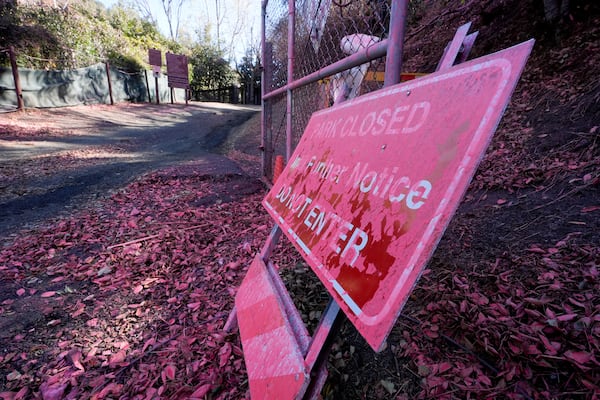 Retardant covers a sign after after crews battled the Palisades Fire in Mandeville Canyon Monday, Jan. 13, 2025 in Los Angeles. (AP Photo/Richard Vogel)