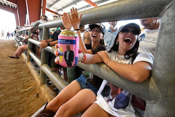 Natalia Kuppers, right, and Sophia Starkey, second from right, of Boca Raton, Fla., cheer while watching teams compete during the Florida Man Games, Saturday, March 1, 2025, in Elkton, Fla. (AP Photo/Phelan M. Ebenhack)