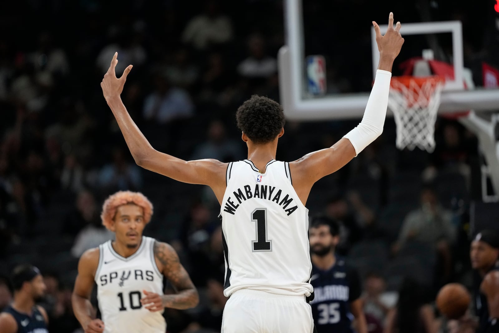 San Antonio Spurs center Victor Wembanyama (1) reacts to a score against the Orlando Magic during the first half of a preseason NBA basketball game in San Antonio, Wednesday, Oct. 9, 2024. (AP Photo/Eric Gay)