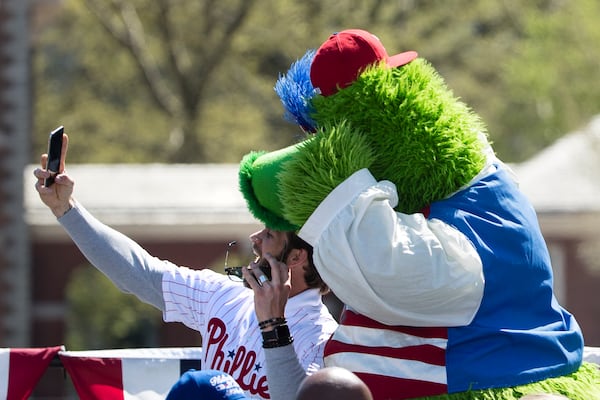 FILE - Philadelphia Phillies' Bryce Harper makes a selfie with the team mascot, the Phillie Phanatic, during a Major League Baseball news conference, April 16, 2019, on Independence Mall in Philadelphia. (AP Photo/Matt Rourke, file)