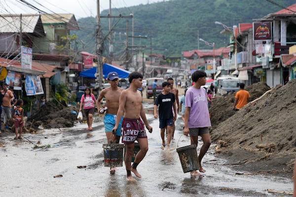 Residents clear out mud from their homes after a recent landslide triggered by Tropical Storm Trami struck Talisay, Batangas province, Philippines leaving thousands homeless and several villagers dead on Saturday, Oct. 26, 2024. (AP Photo/Aaron Favila)