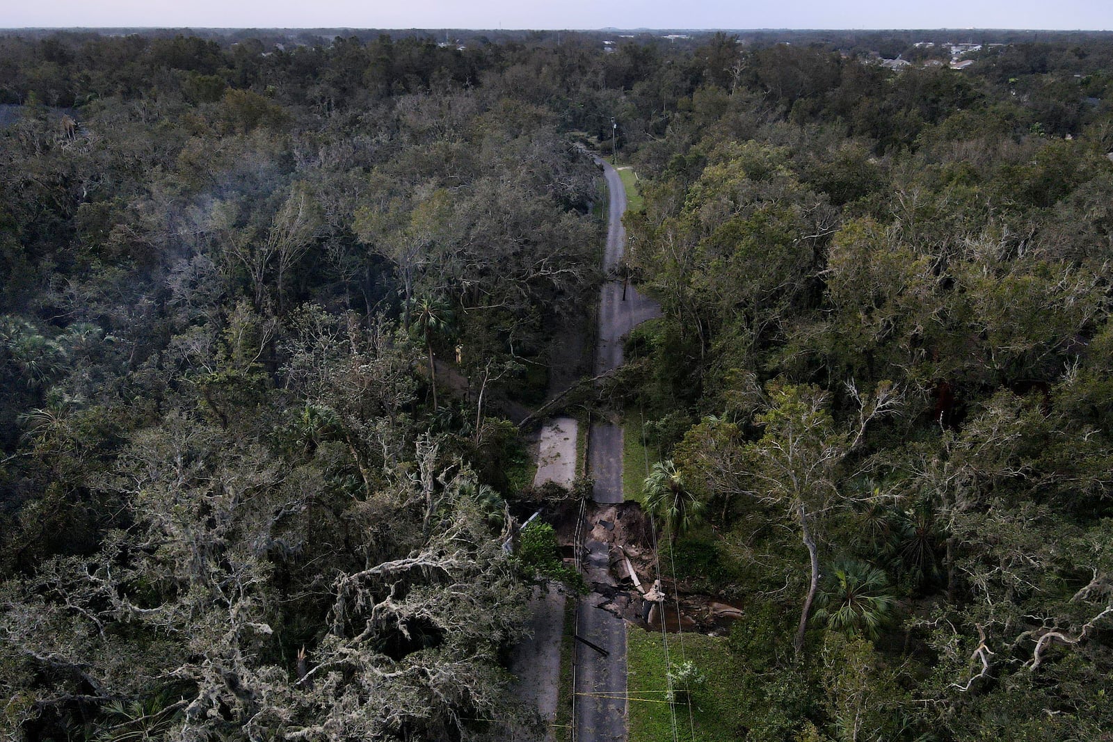 A bridge going over a small creek is seen damaged by Hurricane Milton, Friday, Oct. 11, 2024, in Riverview, Fla. The road is the only access point into a community. (AP Photo/Julio Cortez)