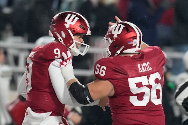 Indiana quarterback Kurtis Rourke (9) celebrates after throwing a touchdown pass with offensive lineman Mike Katic (56) during the first half of an NCAA college football game against Purdue, Saturday, Nov. 30, 2024, in Bloomington, Ind. (AP Photo/Darron Cummings)