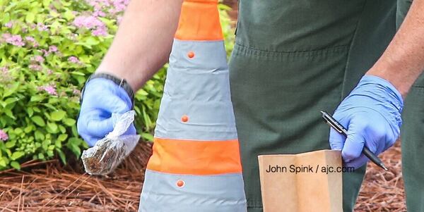 An investigator collects a substance in a plastic bag from an active shooting investigation in Douglas County Wednesday. JOHN SPINK / JSPINK@AJC.COM