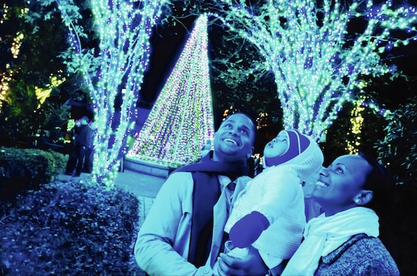 Sam Carter (left) and Tutu Carter (far right), with their daughter Rachel Carter, enjoy Garden Lights, Holiday Nights at the Atlanta Botanical Garden. CONTRIBUTED BY JOEY IVANSCO