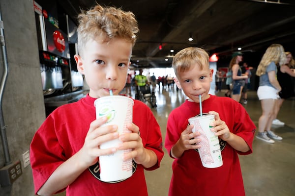 Twin brothers Richard and Daniel Doczi from Dalton enjoy a refreshing beverage using the new biodegradable straws that the Mercedes-Benz Stadium implemented on Sunday, July 17, 2022. The new blue drinking straw breaks down in the environment faster than a typical straw. Miguel Martinez /miguelmartinezjimenezajc.com