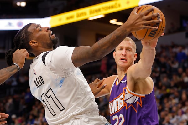 Phoenix Suns center Mason Plumlee, right, challenges Minnesota Timberwolves center Naz Reid (11) for the ball in the second quarter of an NBA basketball game Sunday, Nov. 17, 2024, in Minneapolis. (AP Photo/Bruce Kluckhohn)