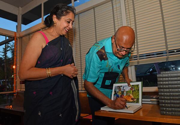 Chef and author Vishwesh Bhatt signs a complimentary copy of his first cookbook, ”I Am From Here: Stories and Recipes From a Southern Chef” (Norton, $37.50), at Chai Pani in Decatur during an Aug. 9, 2022, multicourse dinner celebrating the release of the James Beard Award winner's book. (Chris Hunt for the AJC)