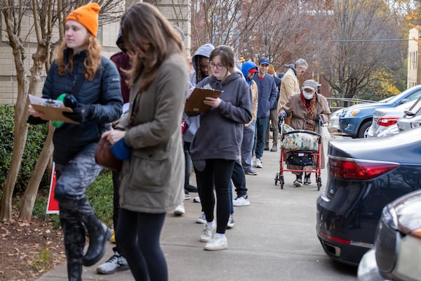 Voters wait in a line stretching down the road from Joan P. Garner Library at Ponce de Leon on the last day of early voting in metro Atlanta on Friday, December 2, 2022.   (Arvin Temkar / arvin.temkar@ajc.com)