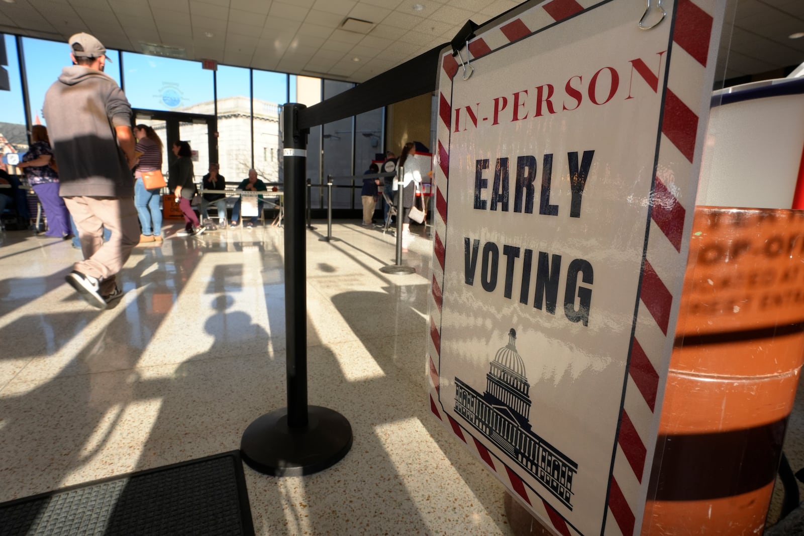 A person walks past a sign during early voting in the general election, Friday, Nov. 1, 2024, in Fall River, Mass. (AP Photo/Steven Senne)