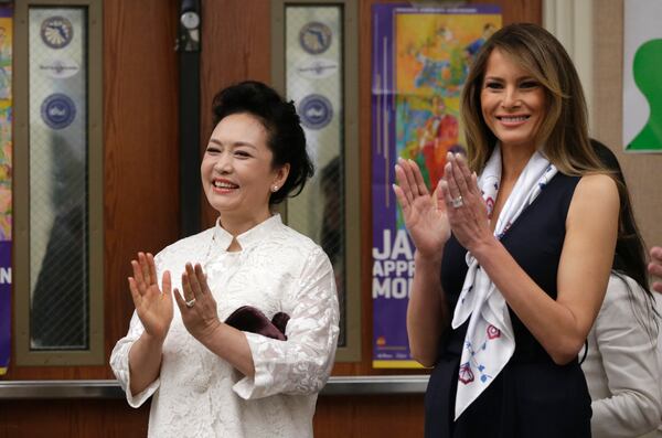 First lady Melania Trump, wife of President Donald Trump, right, and Peng Liyuan, wife of Chinese president Xi Jinping, left, applaud while listening to an orchestra perform while touring the Bak Middle School of the Arts, Friday, April 7, 2017, in West Palm Beach, Fla. (AP Photo/Lynne Sladky)