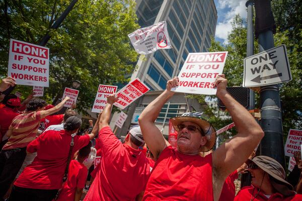 Communications Workers of America demonstrators hold signs during a rally outside of AT&T's offices, Saturday, August 3, 2019, in Atlanta.  BRANDEN CAMP/SPECIAL