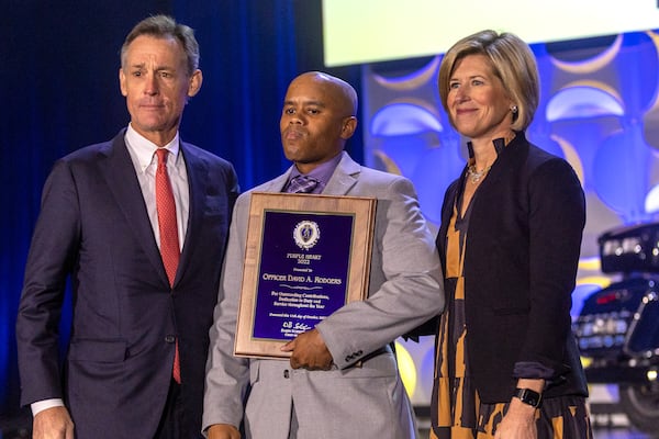 Officer David A. Rodgers (center) accepts his Purple Heart 2022 award during the 18th Annual Crime Is Toast 2022 awards breakfast at the World Congress Center Thursday, Oct. 11, 2022.   Steve Schaefer/steve.schaefer@ajc.com)