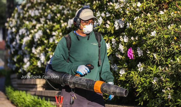 Jesus Balanzar with Gardens to Love always has difficult spring seasons because of the pollen and wears a mask as he works on Westminster Drive in Atlanta.