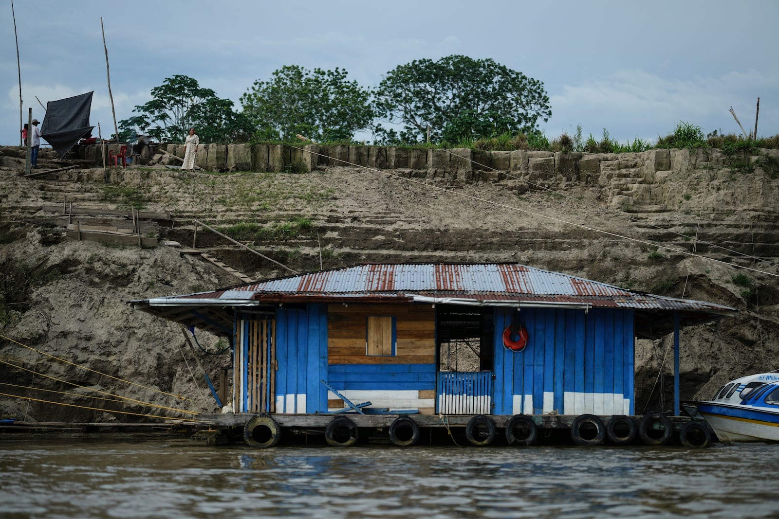 A houseboat floats on low levels of the Amazon River amid a drought in Leticia, Colombia, Sunday, Oct. 20, 2024. (AP Photo/Ivan Valencia)