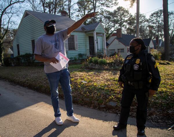 Jason Hudgins (left) passes out flyers in his neighborhood Thursday as authorities search for clues in the fatal shooting of 12-year-old David Mack. 