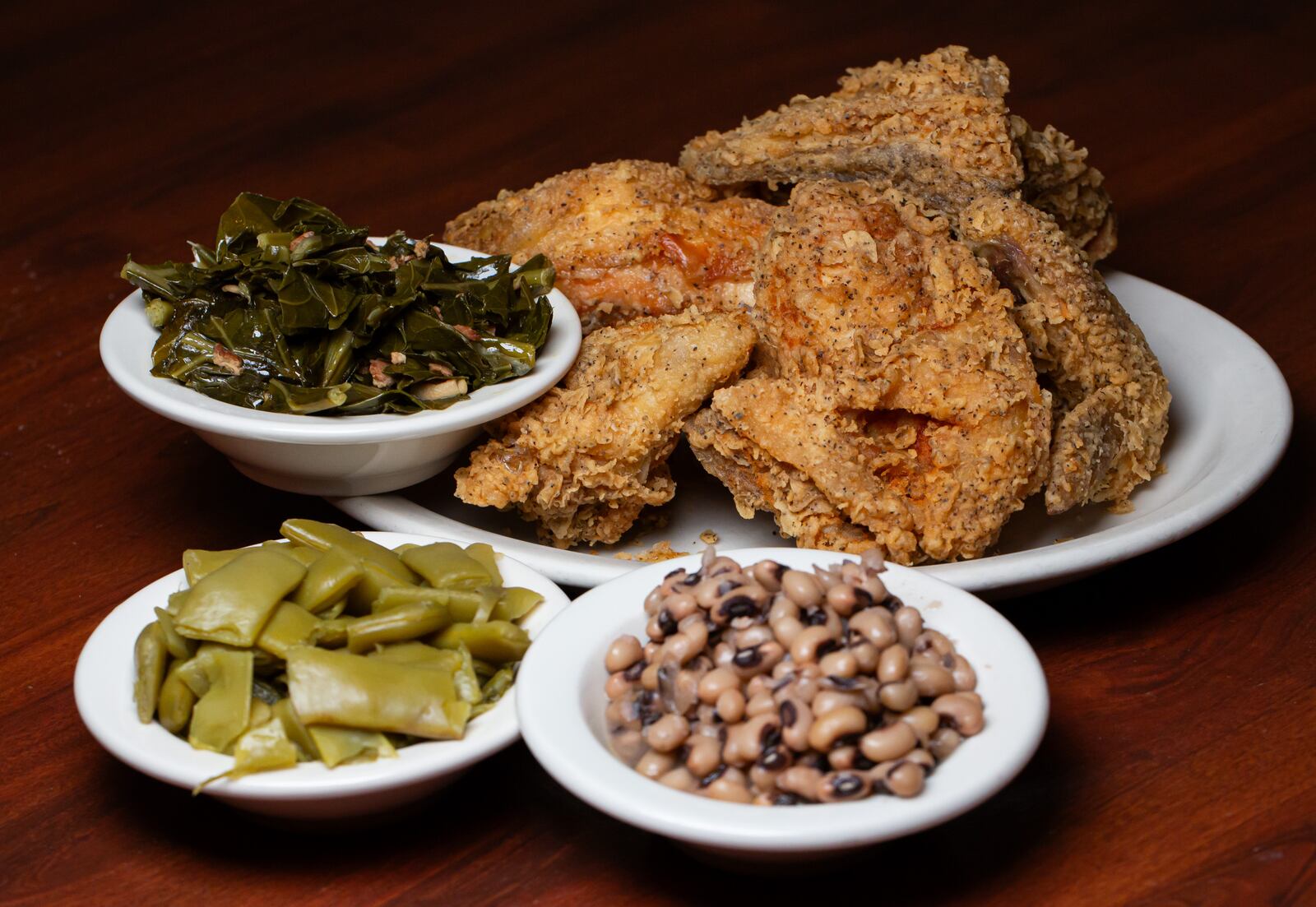 Atlanta, GA: Fried chicken has been a staple at longstanding Atlanta institution Colonnade off of Cheshire bridge. Shown with collard greens, green beans, and black eyed peas. AAJC 101523 DG fave comfort foods (Ryan Fleisher FOR THE ATLANTA JOURNAL-CONSTITUTION)