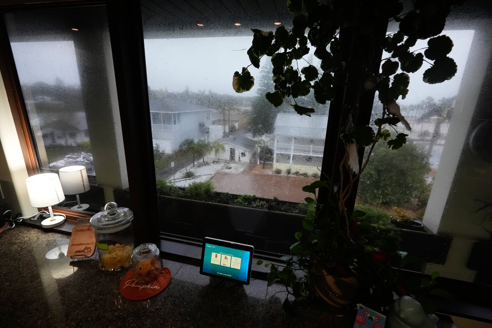 Neighboring homes, a pile of debris and a garage damaged in Hurricane Helene, are seen from the third-floor of the home where Christian Burke, his mother and aunt will ride out Hurricane Milton, in Gulfport, Fla., Wednesday, Oct. 9, 2024. Burke, who said his engineer father built the concrete home to withstand a Category 5 hurricane, expects his raised ground floor to flood severely, but for the building to remain standing. (AP Photo/Rebecca Blackwell)