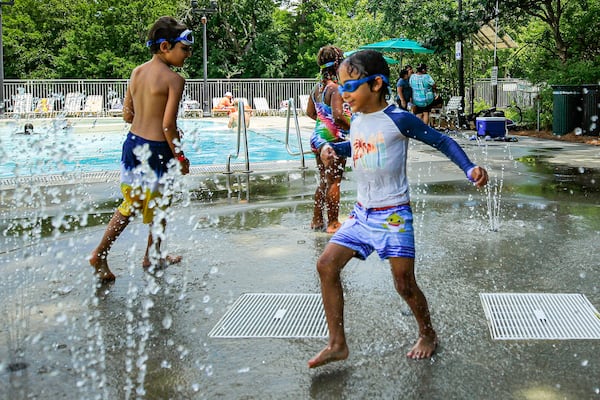 Elias Sperry, 5, (right), runs across a water fountain in Piedmont Park in Atlanta on Friday, July 5, 2024.  (Ziyu Julian Zhu / AJC)