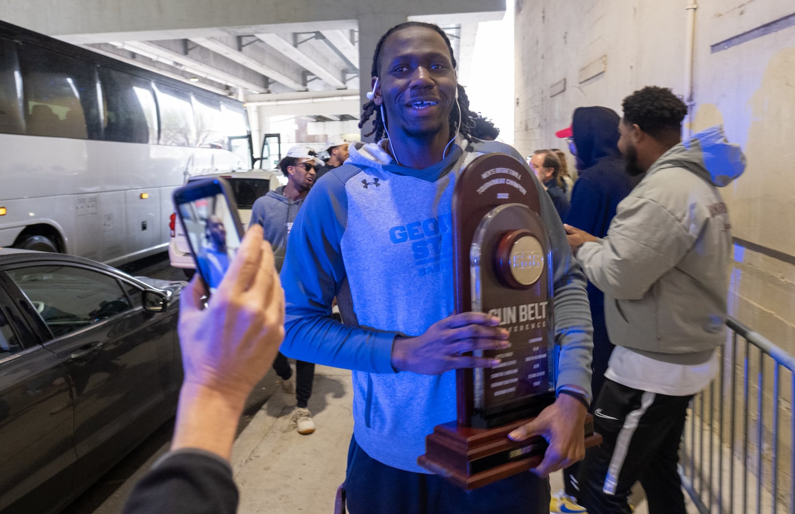 220308-Atlanta-Joe Jones III carries the Sun Belt Conference championship trophy as the team returns home Tuesday, March 8, 2022, after the team won the championship. Ben Gray for The Atlanta Journal-Constitution