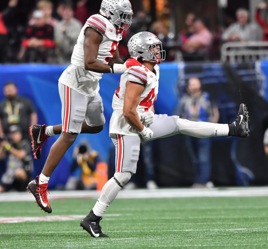 Ohio State Buckeyes defensive end J.T. Tuimoloau (44) celebrates after a sack of Georgia Bulldogs quarterback Stetson Bennett (13) during the third quarter of the College Football Playoff Semifinal between the Georgia Bulldogs and the Ohio State Buckeyes at the Chick-fil-A Peach Bowl In Atlanta on Saturday, Dec. 31, 2022. (Hyosub Shin / Hyosub.Shin@ajc.com)