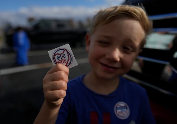 Isaac Young, 5, holds up an "Ohio Voted" sticker outside the Trenton Township polling place after watching his dad, Mike Young, vote for Donald Trump on Election Day, Tuesday, Nov. 5, 2024, in Sunbury, Ohio. (AP Photo/Carolyn Kaster)