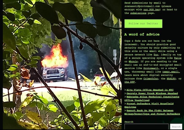 A screenshot of a post on "Scenes from the Atlanta Forest," a blog with contributions by far left activists trying to stop the construction of Atlanta's new public safety training center. The image shows a tow truck purportedly set ablaze by activists.