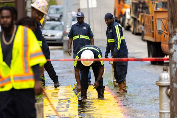 Workers take care of a water main break at Joseph E. Boone Boulevard and James P. Brawley Drive in Atlanta on Friday, May 31, 2024. (Arvin Temkar / AJC)