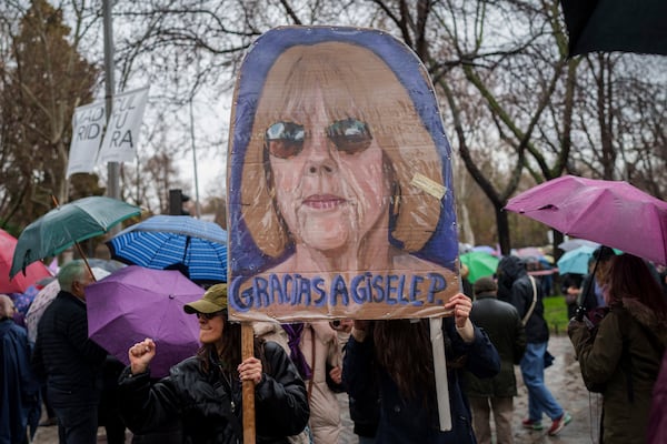 Demonstrators hold a poster depicting Gisele Pélicot during an International Women's Day protest in Madrid, Spain, Saturday, March 8, 2025. (AP Photo/Bernat Armangue)