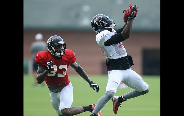 Falcons wide receiver Devin Hester catches a pass in front of cornerback Travis Howard during team practice Tuesday in Flowery Branch. Curtis Compton/www.ajc.com