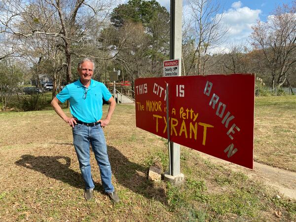 Roswell resident Jason Yowell has signs posted on his riverbank property that are critical of the city. Credit: Adrianne Murchison