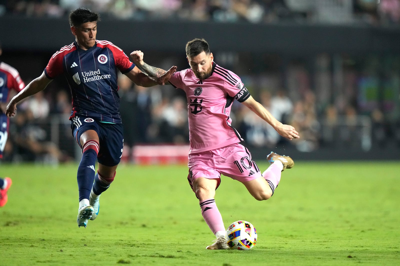 Inter Miami forward Lionel Messi (10) kicks the ball to score a goal as New England Revolution defender Xavier Arreaga, left, defends during the second half of an MLS soccer match, Saturday, Oct. 19, 2024, in Fort Lauderdale, Fla. (AP Photo/Lynne Sladky)