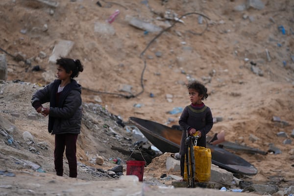 Displaced Palestinians girls fill a plastic jerrycan with water at a school run by UNRWA, the U.N. agency helping Palestinian refugees, which they use as a shelter west of Gaza City, Sunday, March 9, 2025. (AP Photo/Jehad Alshrafi)