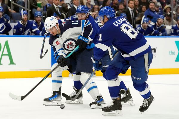 Winnipeg Jets center Gabriel Vilardi (13) loses the puck to Tampa Bay Lightning defenseman Erik Cernak (81) during the third period of an NHL hockey game Thursday, Nov. 14, 2024, in Tampa, Fla. (AP Photo/Chris O'Meara)