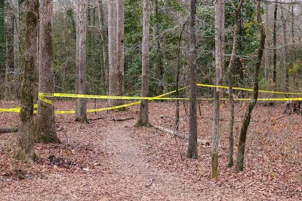 Police tape ropes off the crime scene on a trail behind Lake Herrick in Athens at the University of Georgia on Friday, Feb. 23, 2024. A female nursing student was found dead nearby the day before. (Jason Getz / jason.getz@ajc.com)