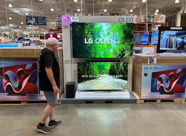 FILE - A shopper examines large-screen televisions on display in a Costco warehouse on Sept. 19, 2024, in Lone Tree, Colo. (AP Photo/David Zalubowski, File)