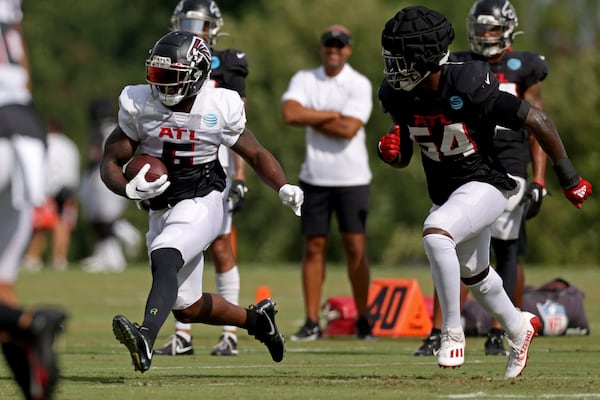 Falcons running back Damien Williams runs after a catch against inside linebacker Rashaan Evans during training camp. (Jason Getz / Jason.Getz@ajc.com)