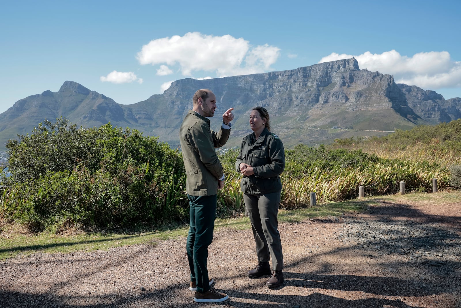 Britain's Prince William talks with Park Manager for Table Mountain National Park Megan Taplin, right, with Table Mountain in the background, while visiting Signal Hill in Cape Town, South Africa, Tuesday, Nov. 5, 2024. (Gianluigi Guercia/Pool via AP)