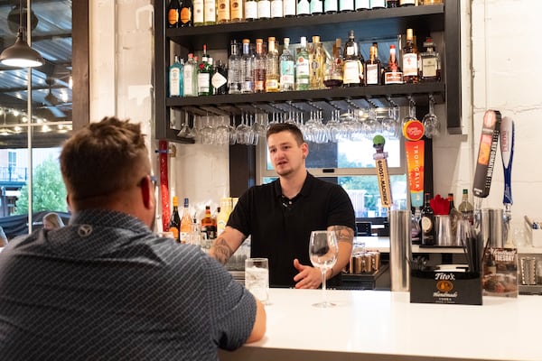 Bartender Austin Byrd talks with customer Marcus Sizemore at the Canton location of the Italian restaurant Campania. At some Campania locations, bartenders make up to $100,000 with tips, which President-elect Donald Trump has said should no longer be taxed. (Ben Gray for The Atlanta Journal-Constitution)