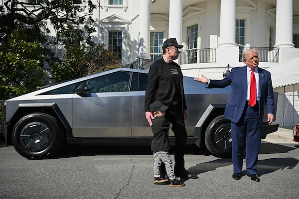 President Donald Trump and Tesla CEO Elon Musk, along with his son X Æ A-Xii, speaks to reporters by a Tesla vehicle on the South Lawn of the White House Tuesday, March 11, 2025, in Washington. (Pool via AP)