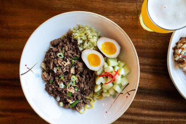 Zha Jiang Ramen, brothless ramen with minced pork in rich black bean sauce, soft boil egg, pickled mustard greens, fresh cucumber salad and scallions, and a HopStix Kungfu Hops draft beer. Photo credit- Mia Yakel.