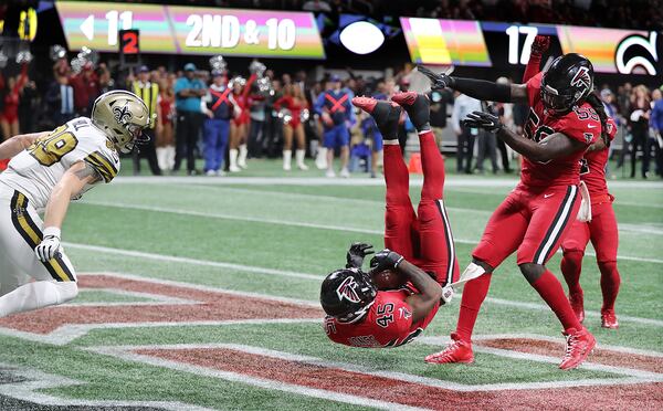 Deion Jones lands with a game-clinching, endzone interception of the Saints Drew Brees in 2017. Guess who that Falcon is next to him?  (Curtis Compton/ccompton@ajc.com)