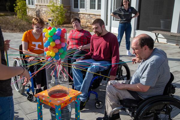 Josh Cusick (far right) tries to pull a stick out without dropping the balls during a game with Brenau Occupational Therapy students at Champions Place. PHIL SKINNER FOR THE ATLANTA JOURNAL-CONSTITUTION.