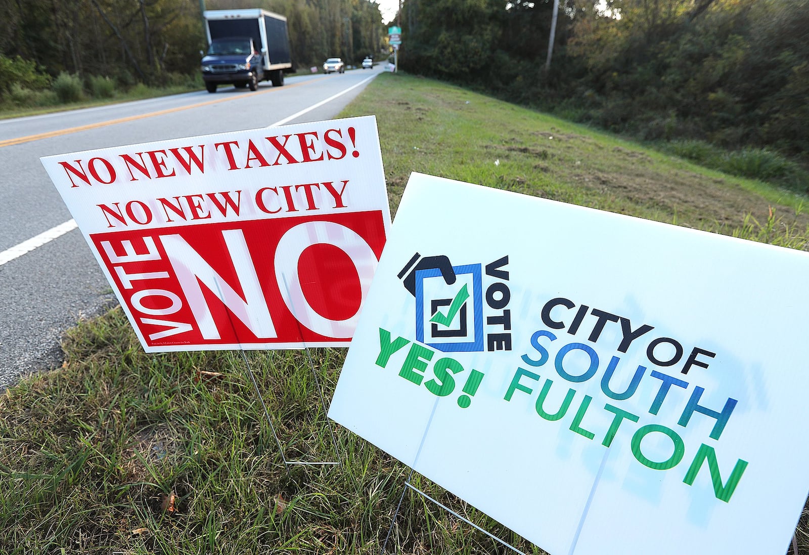 Traffic on Enon Road passes by signs for and against forming the City of South Fulton. Curtis Compton /ccompton@ajc.com