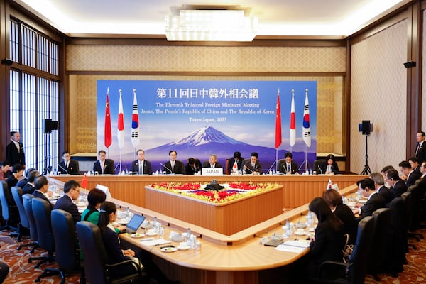 Japanese Foreign Minister Takeshi Iwaya, center, welcomes Chinese Foreign Minister Wang Yi and the South Korean Foreign Minister Cho Tae-yul during their trilateral foreign ministers' meeting in Tokyo Saturday, March 22, 2025.(Rodrigo Reyes Marin/Pool Photo via AP)