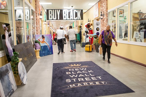 Customers walk among the storefronts at the New Black Wall Street Market, on Saturday, October 15, 2022, in Lithonia, Georgia. The market has been in operation for over a year and gives black business owners the opportunity to sell their products. CHRISTINA MATACOTTA FOR THE ATLANTA JOURNAL-CONSTITUTION